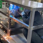 作業台の下に潜り込んで溶接